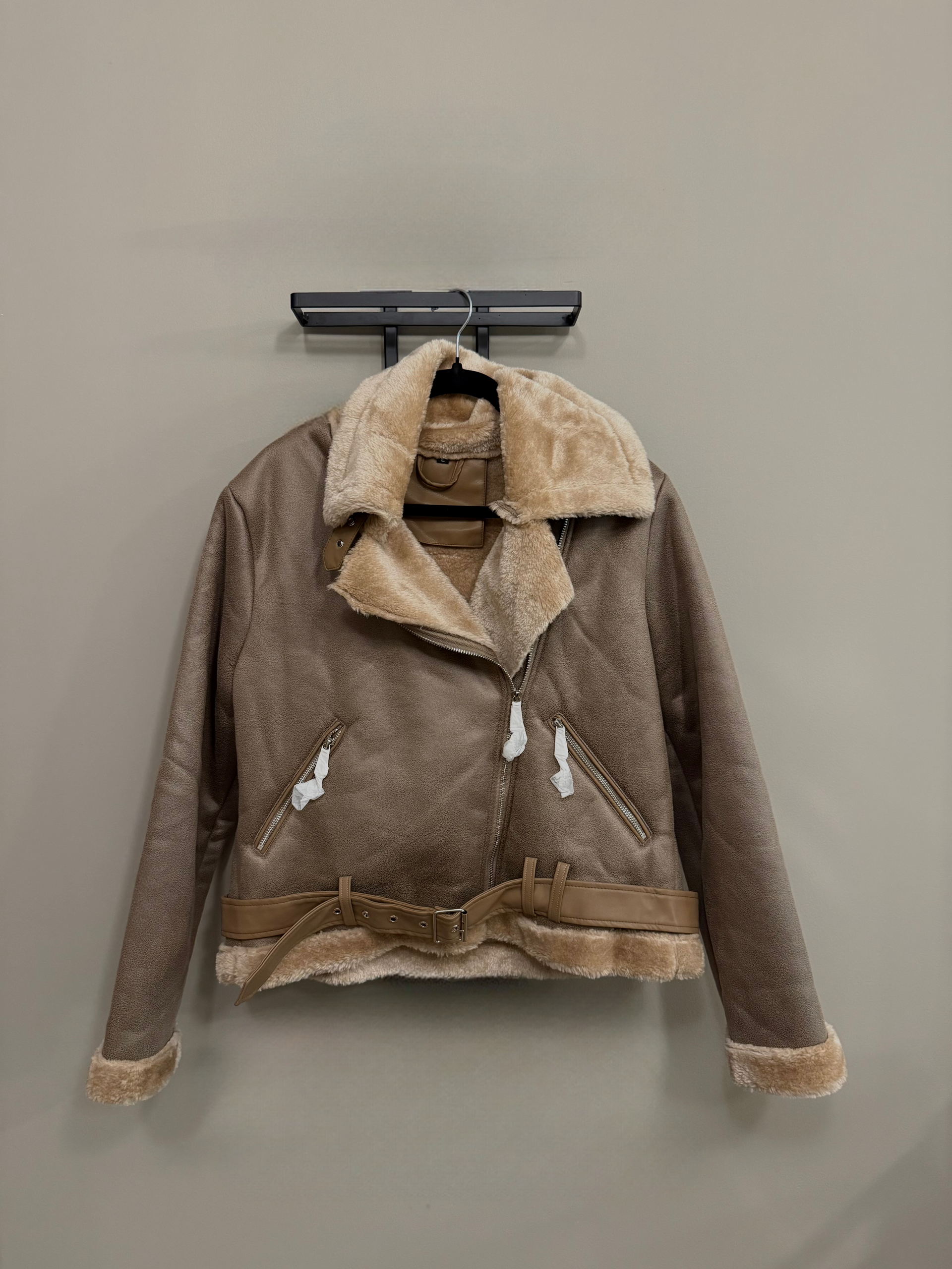 Chaqueta de ante color topo con forro de piel, cinturón y detalles de cremallera.