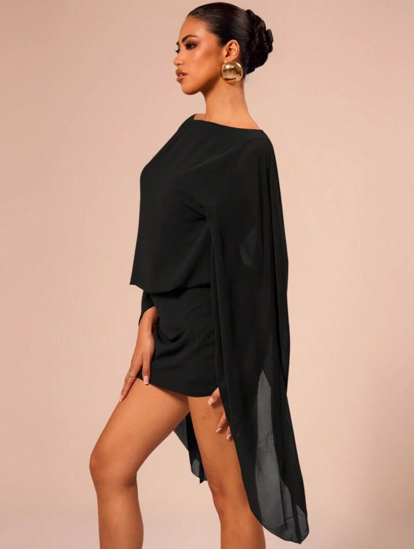 Vestido mini negro con mangas sueltas y fluidas.