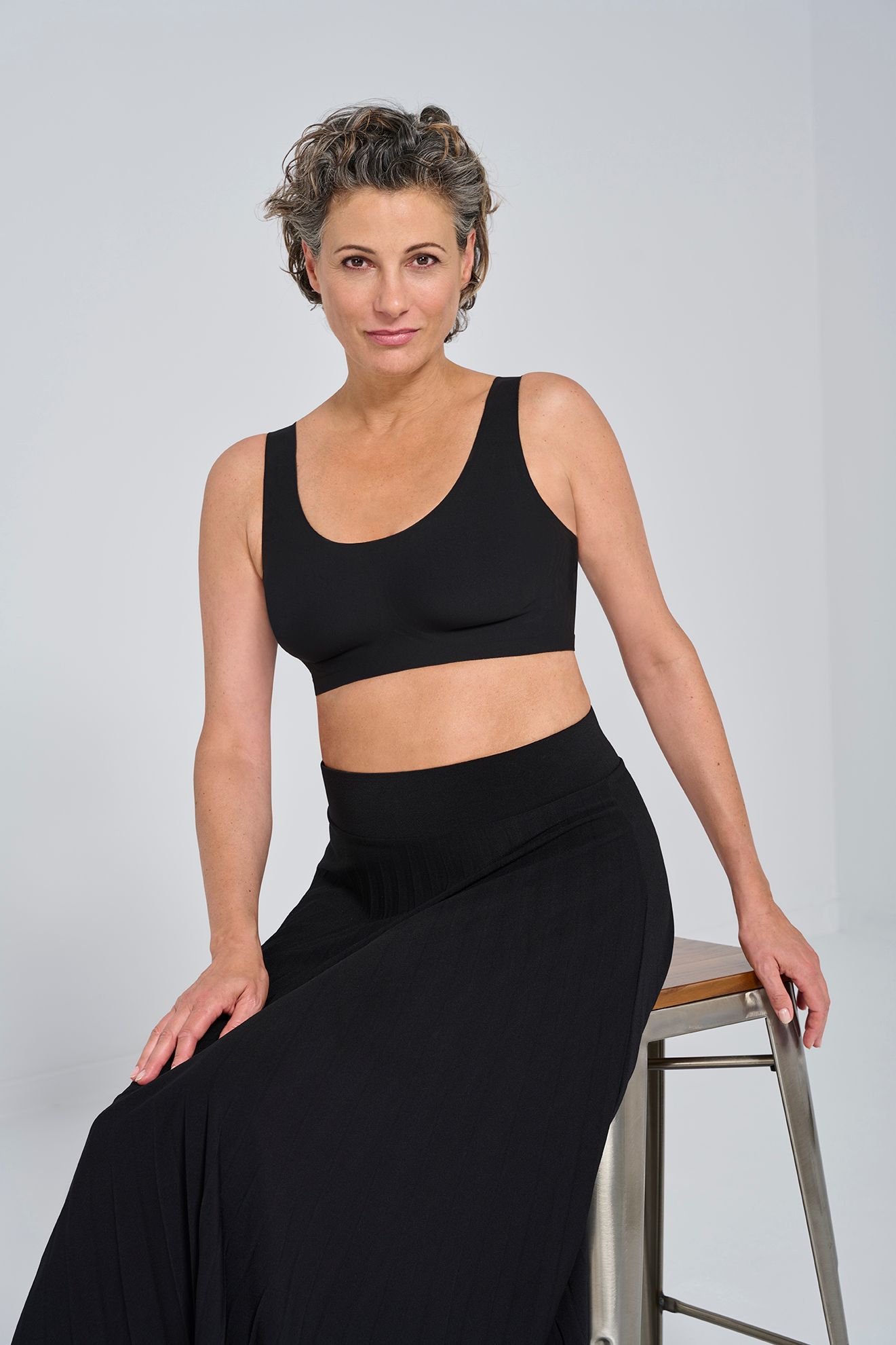 A sports bra is a specialized type of bra designed to provide support and comfort during physical activities, particularly exercise and sports. It typically features a snug fit and is made from breathable, moisture-wicking fabric to keep the wearer dry and comfortable. Sports bras often have wider straps and a racerback design to distribute pressure evenly and minimize movement of the breasts during high-impact activities. They come in various levels of support, ranging from low-impact for activities like yoga to high-impact for running and intense workouts. Sports bras help reduce breast discomfort, minimize breast movement, and provide necessary support, contributing to a more comfortable and confident workout experience.