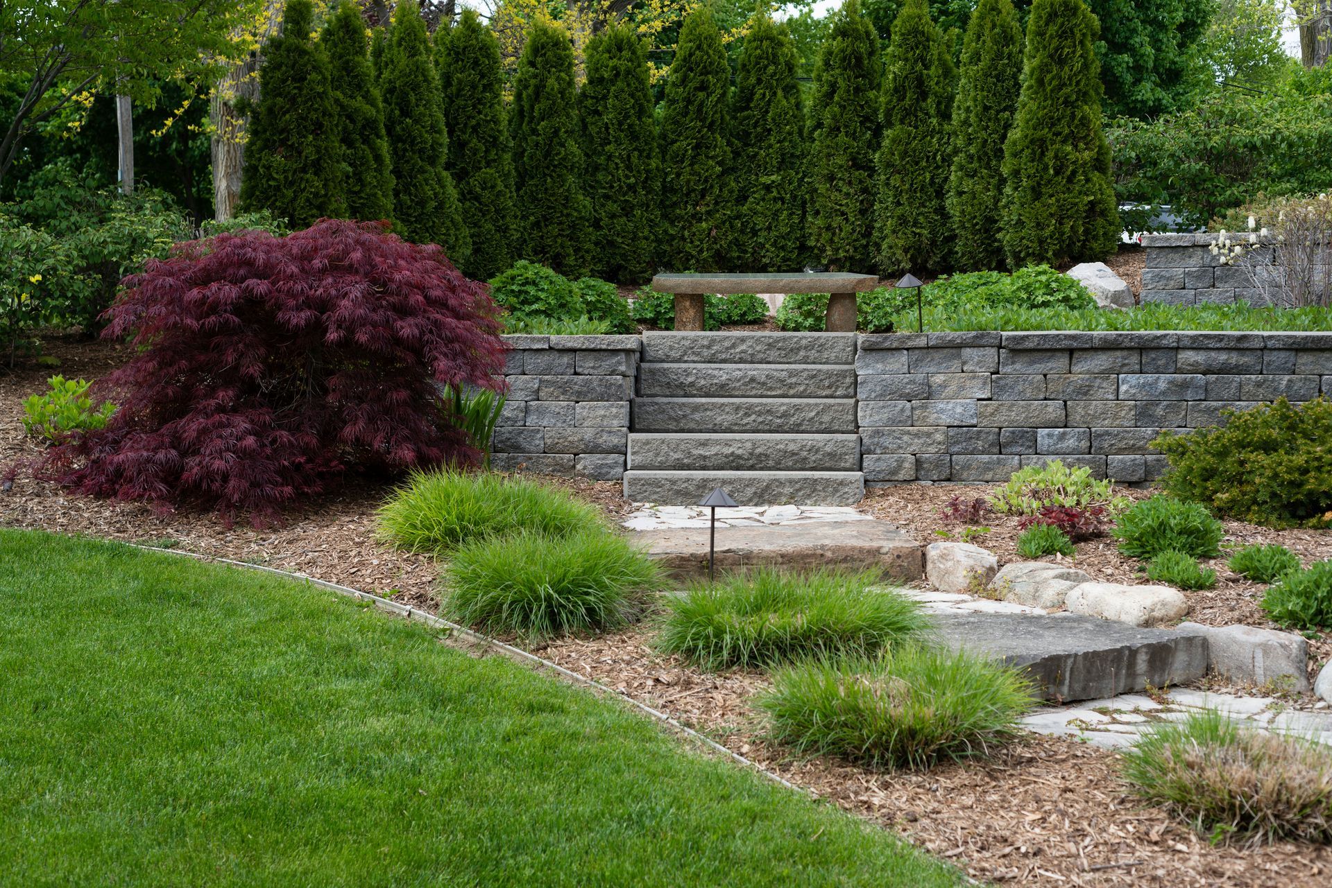 Stone path and steps featured in a professionally designed and maintained landscape