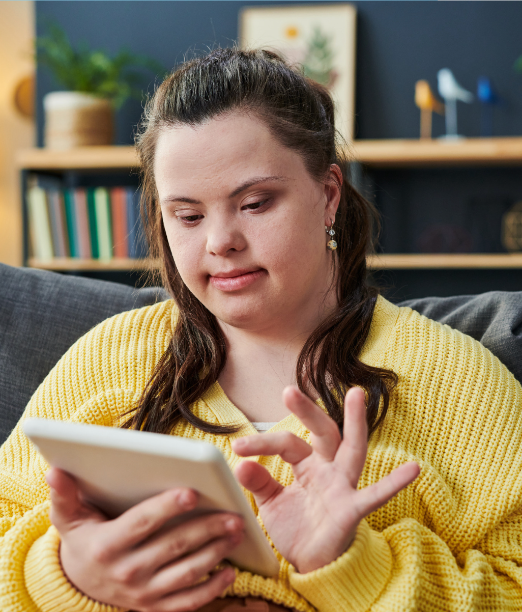A man is sitting at a table using a laptop computer.