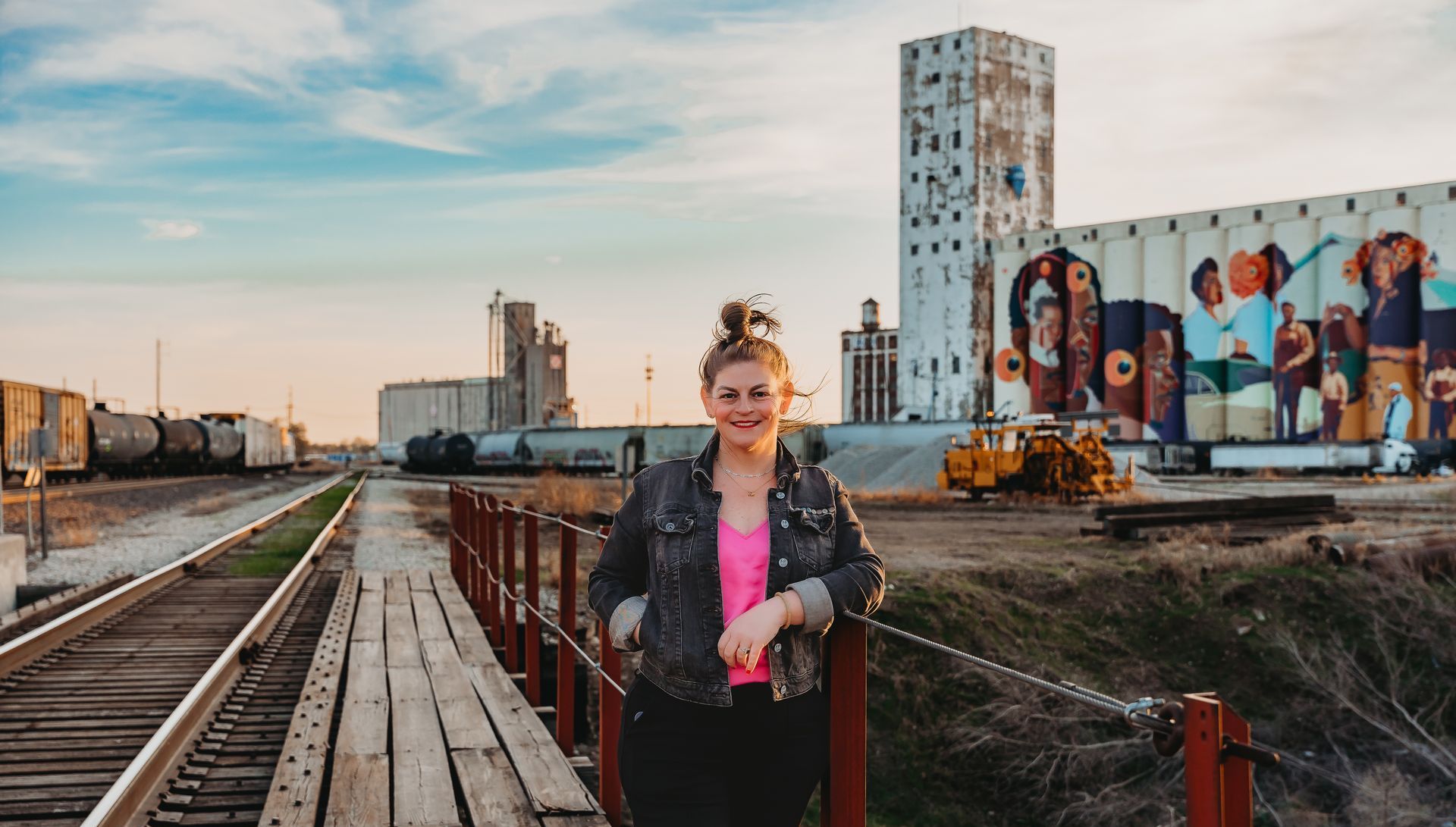 Maggie Ballard standing in front of a Wichita painting, highlighting her connection to the community.