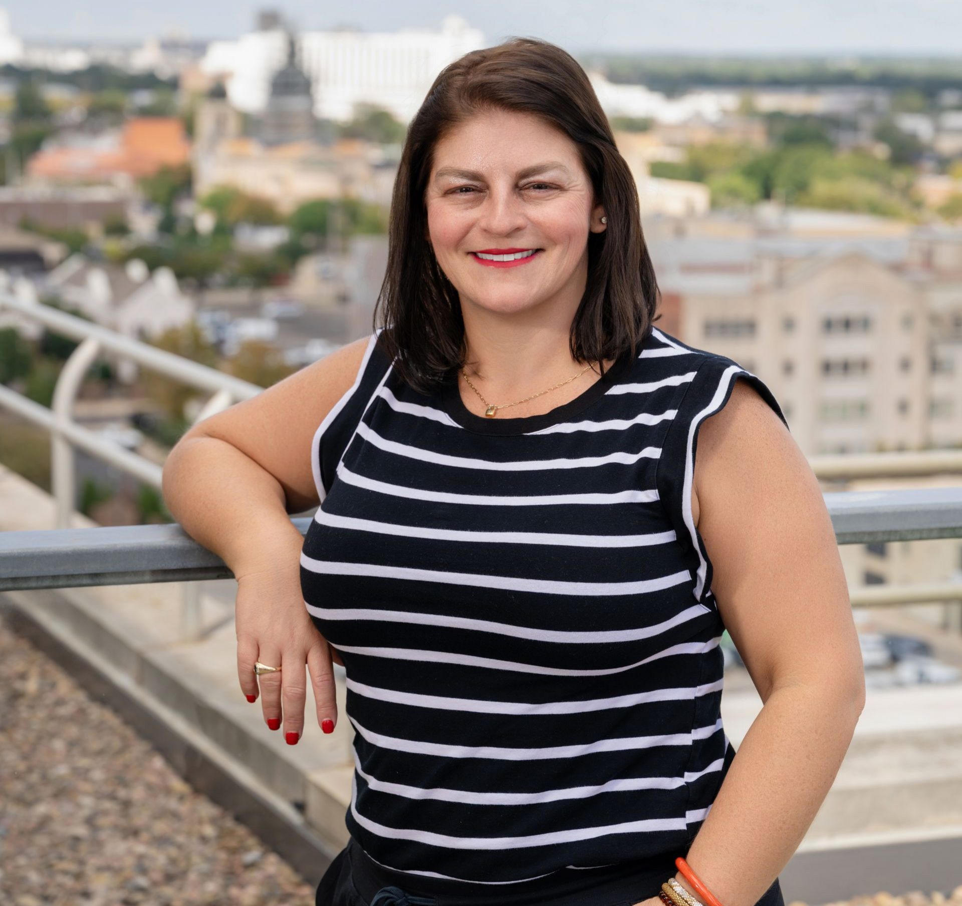 Maggie Ballard standing in front of a Wichita painting, highlighting her connection to the community.