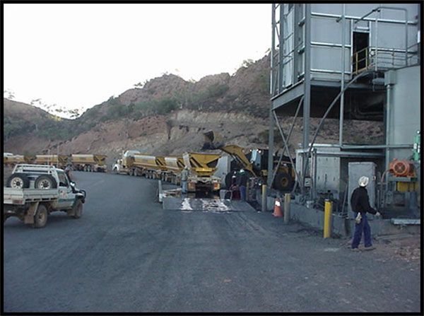 A row of trucks are parked in a parking lot in front of a building