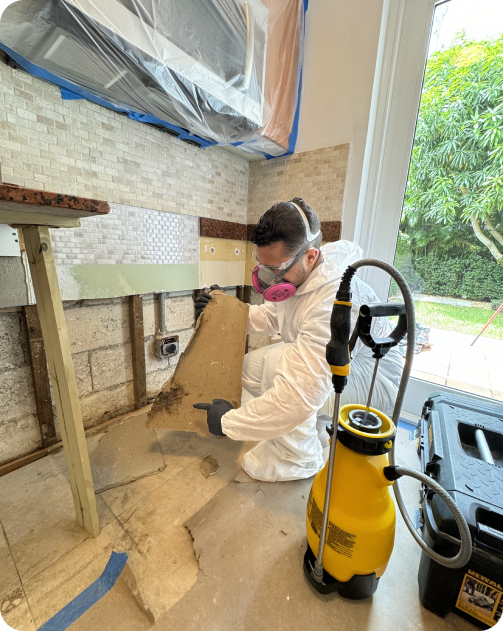 A man in a protective suit is working in a kitchen.