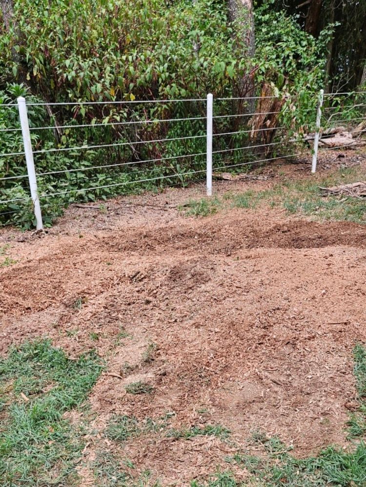 A fence is sitting in the middle of a dirt field.