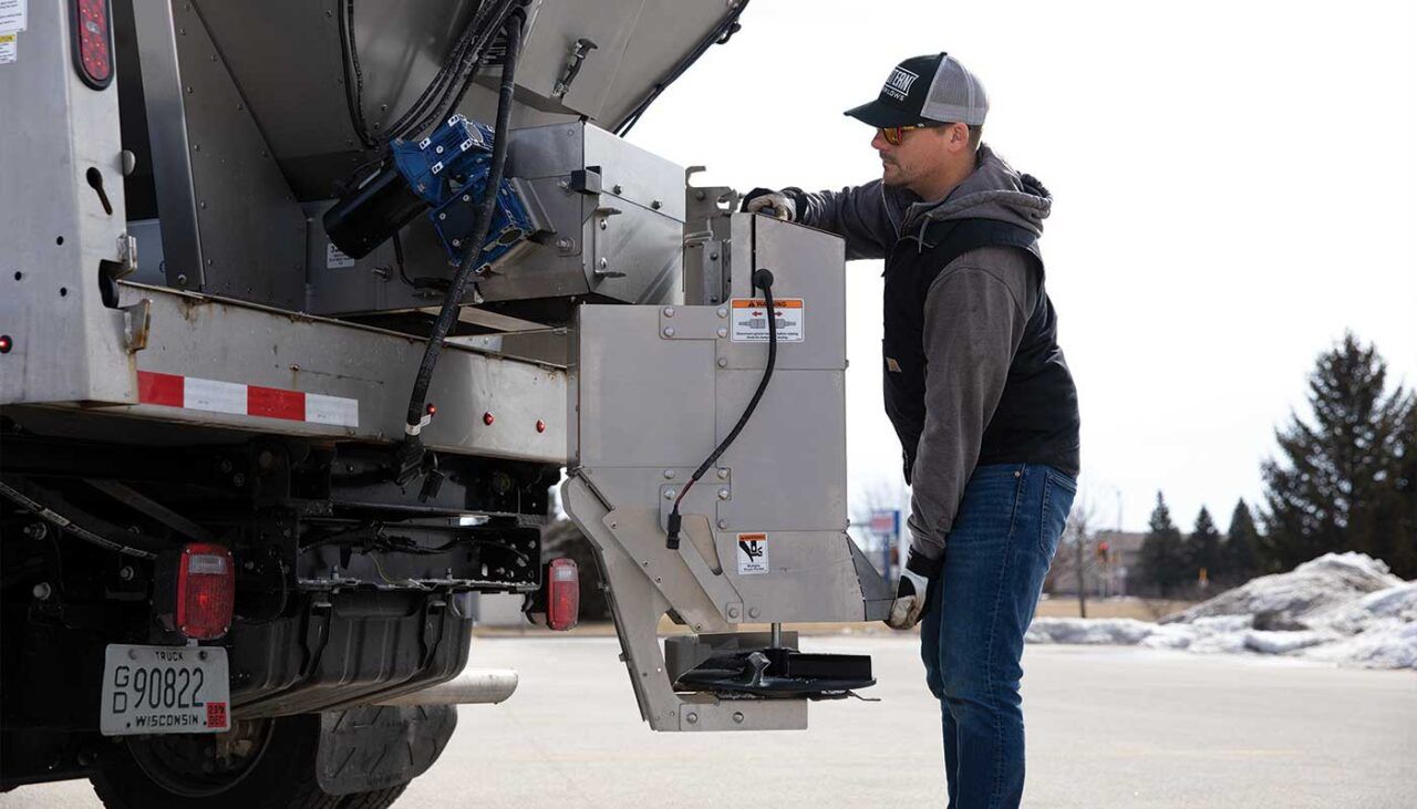 Man Putting Salt On The Salt Spreader — Destin, FL — Destin Discount Granite And Cabinets