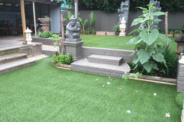 residential living space with artificial grass and stair