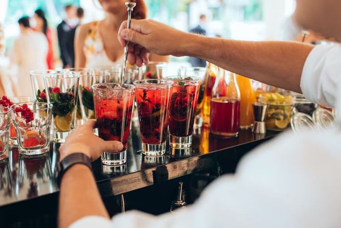 A bartender is preparing a drink at a wedding reception.