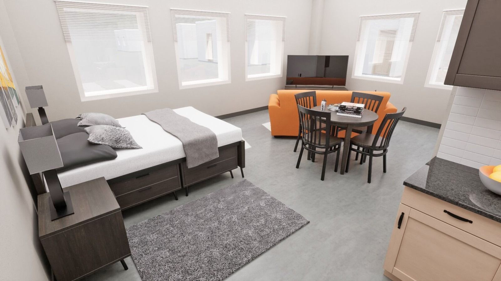 Small apartment with a bed, seating area, dining table, and kitchen; gray, orange, and brown tones.