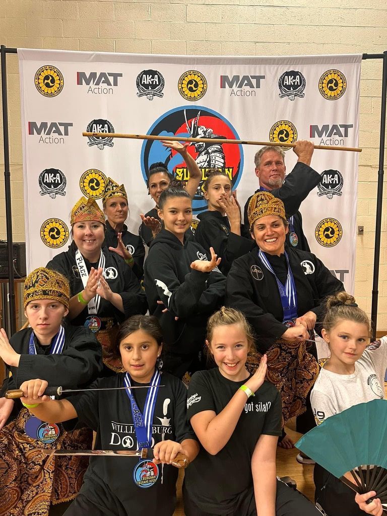 A group of young people are posing for a picture in front of a banner.