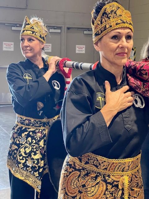 Two women are standing next to each other with their hands on their chests