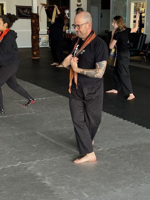 A group of people are practicing martial arts in a gym