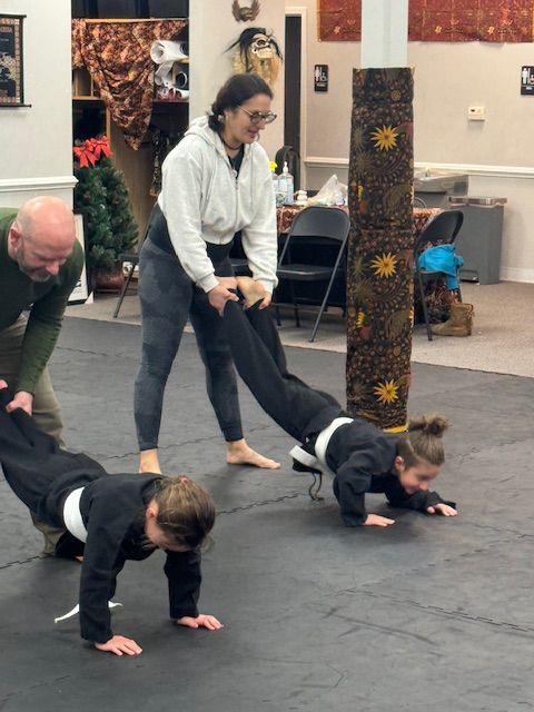 A group of people are doing push ups on a mat