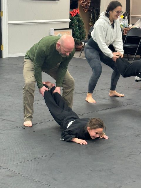 A group of people are practicing martial arts on a mat.