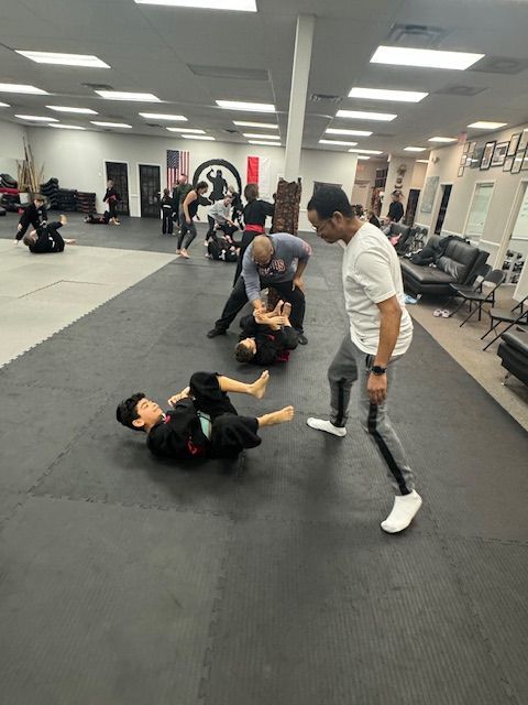 A group of people are practicing martial arts in a gym.