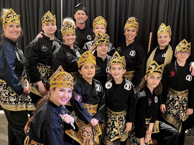 A group of people are posing for a picture in front of a black curtain.