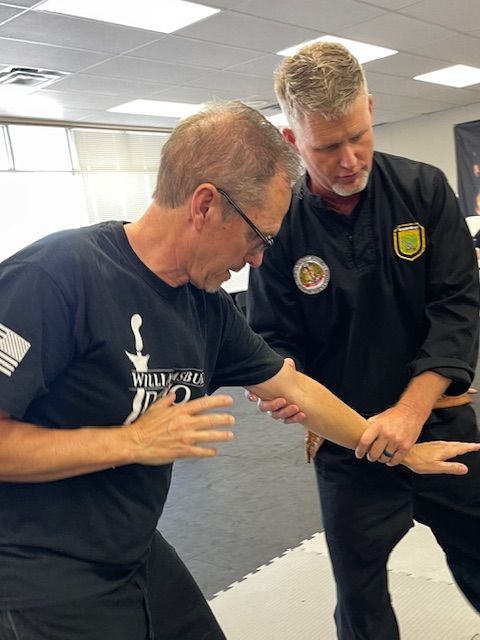 Two men are practicing martial arts in a gym.