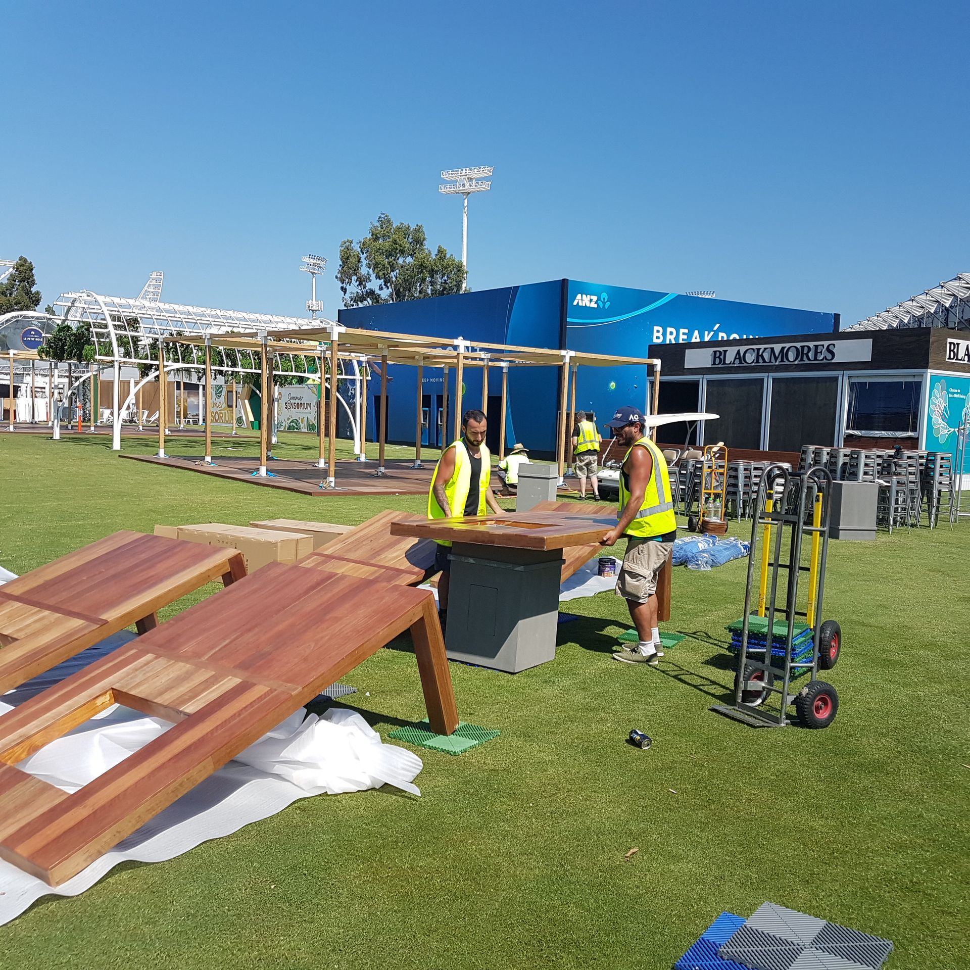 A man in a yellow vest is working on a wooden table