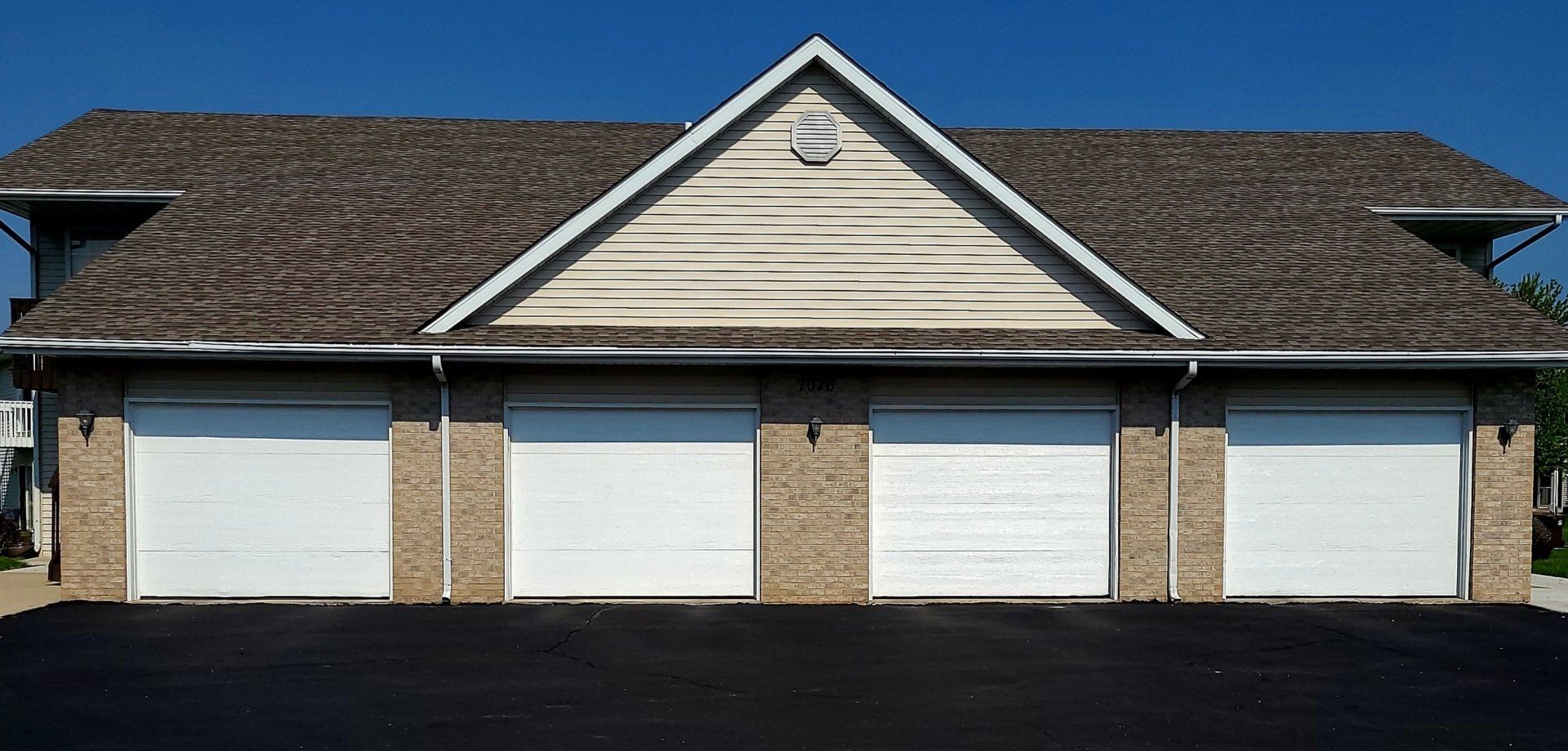 A house with three garage doors and a triangle roof