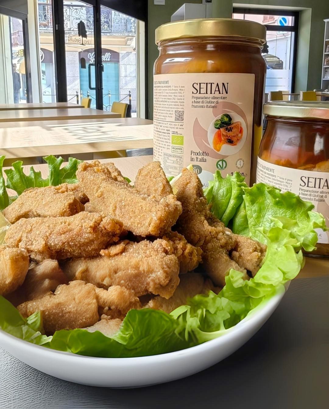 Una ciotola di cibo con un barattolo di salsa seitan sullo sfondo