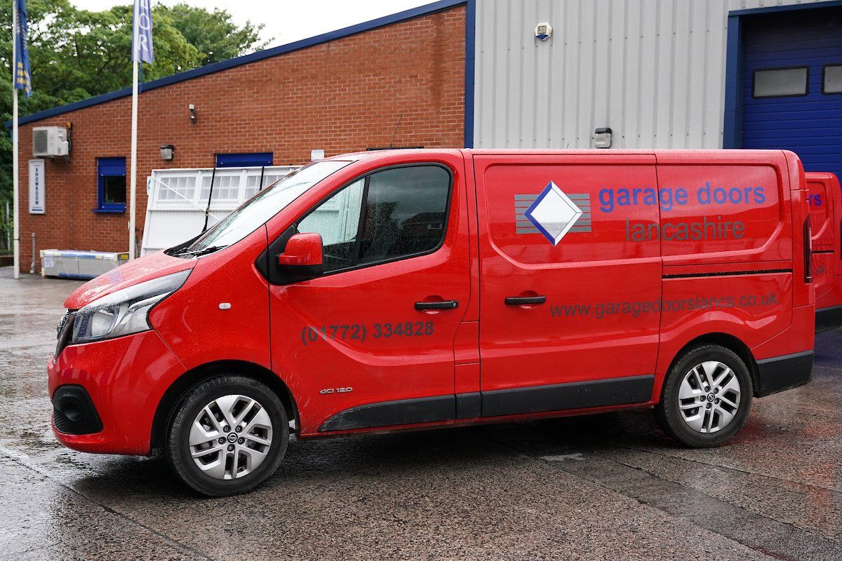 A sign-written red van with Garage Doors Lancashire and their contact details on the side