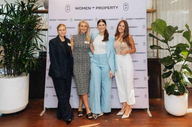 Four people stand smiling in front of a