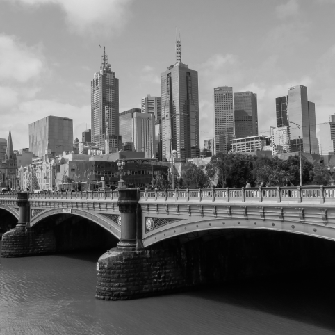Black and white view of the Princes Bridge spanning the Yarra River with Melbourne's skyline in the background.