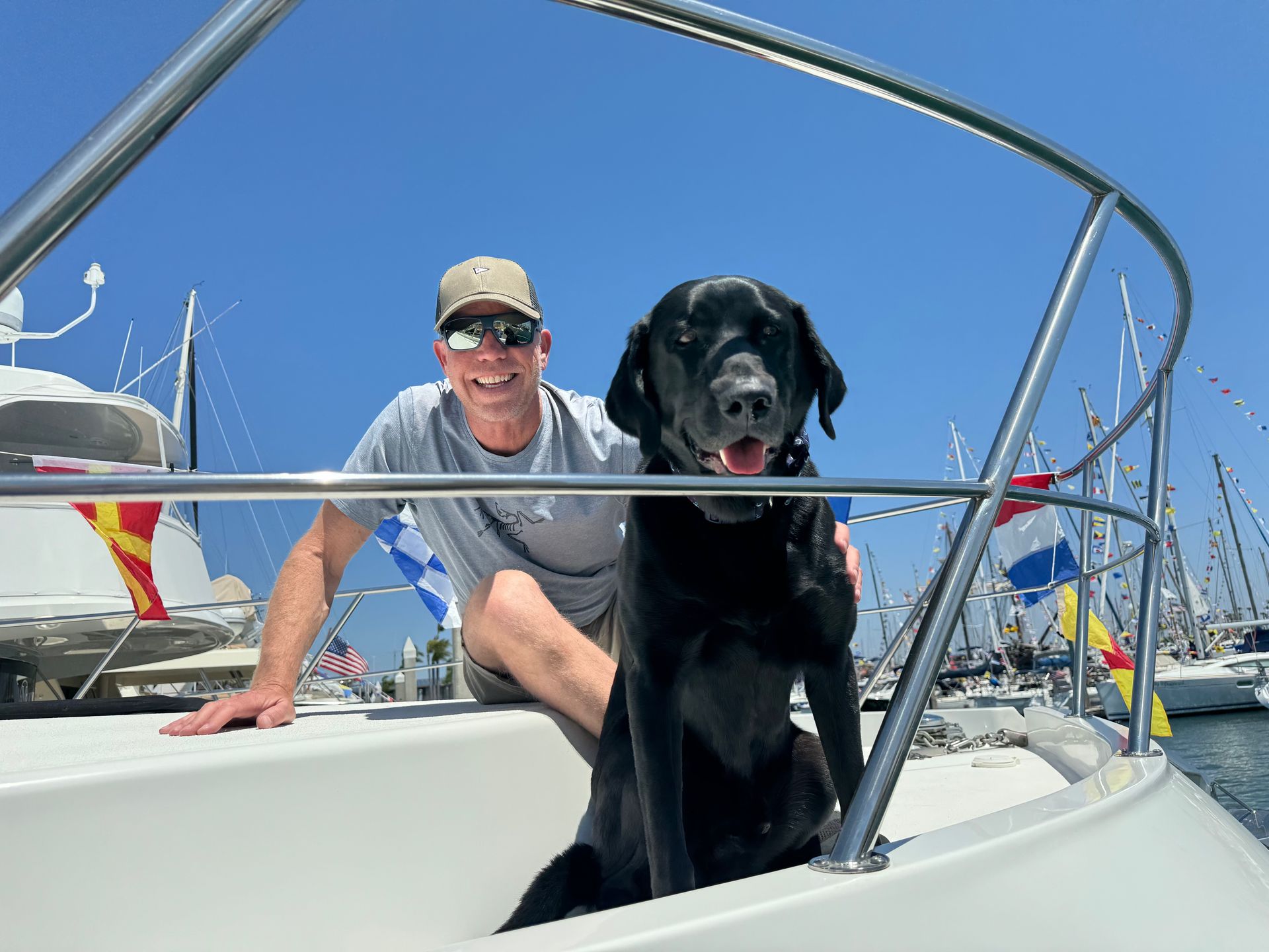 A man and a black dog are on a boat