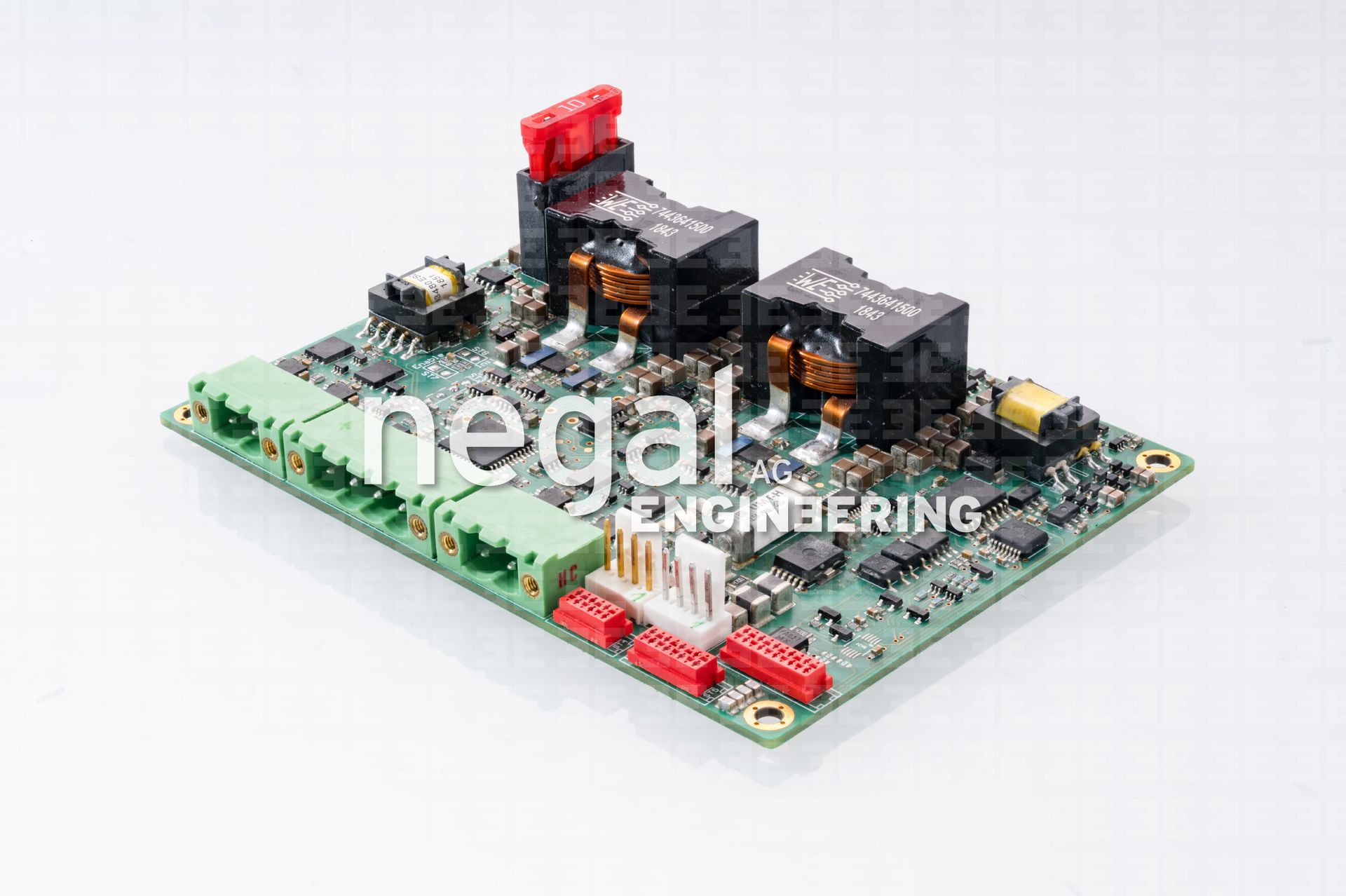 Leiterplatte mit grünen Anschlüssen, schwarzen Transformatoren und verschiedenen elektronischen Komponenten.