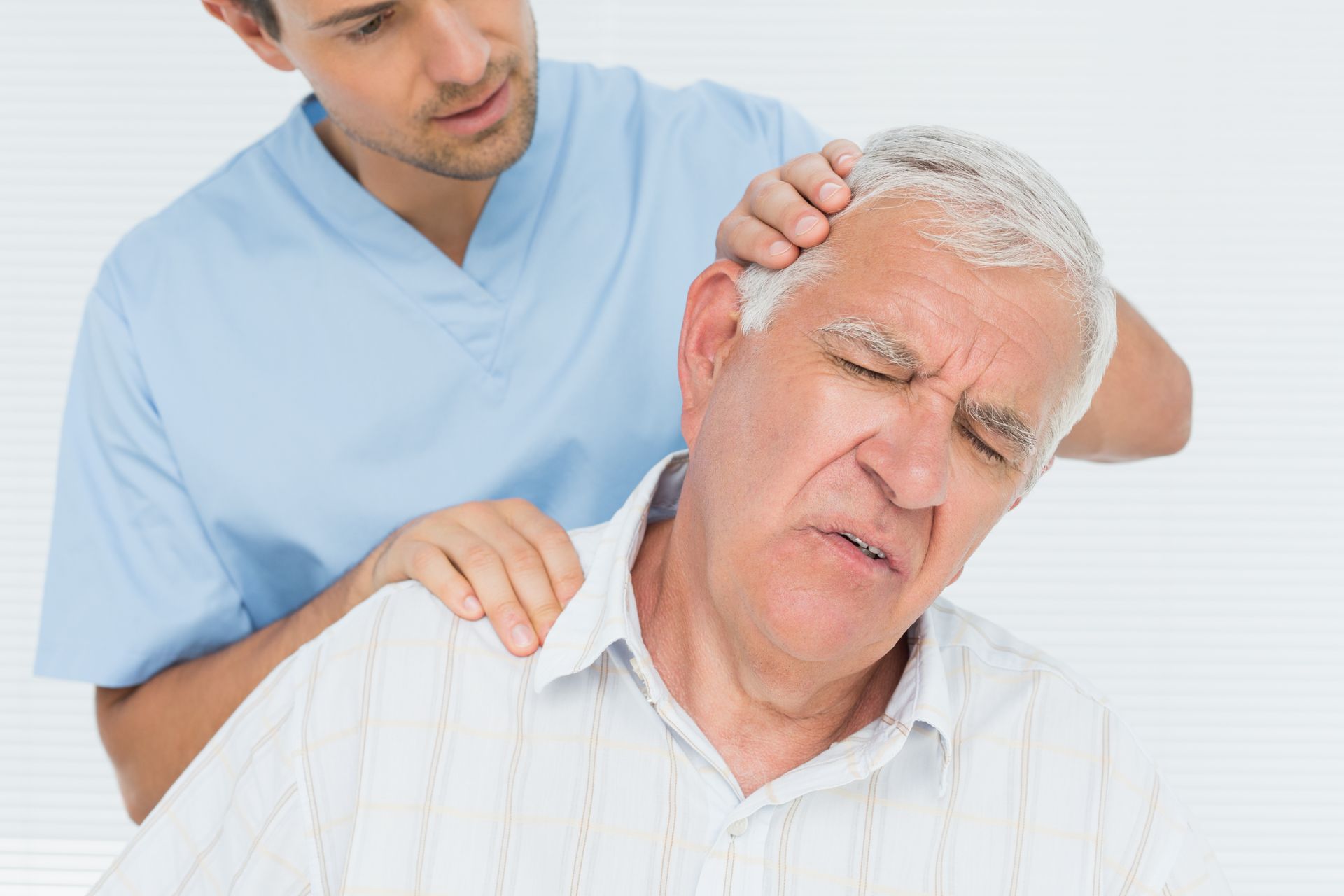 A man is giving an older man a neck massage.