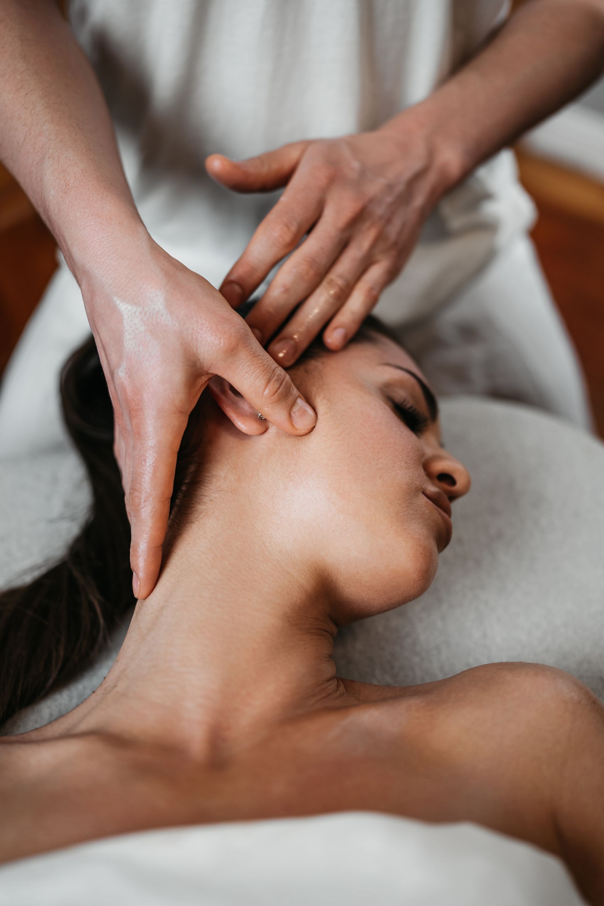 A woman is getting a head massage at a spa.