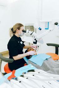 Dentist examining patient's teeth with microscope in a dental office.