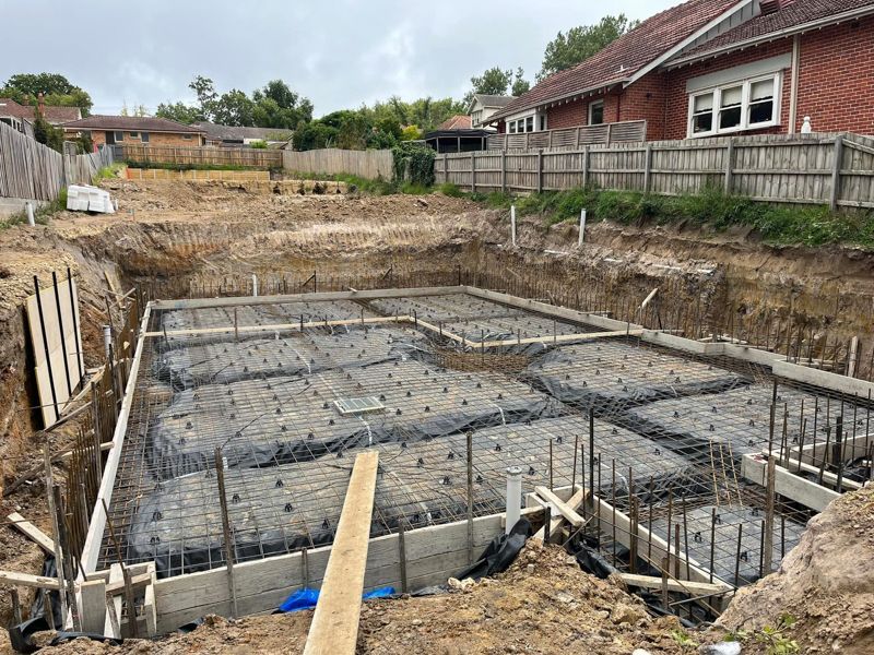 A semi truck is carrying a large excavator on a trailer.