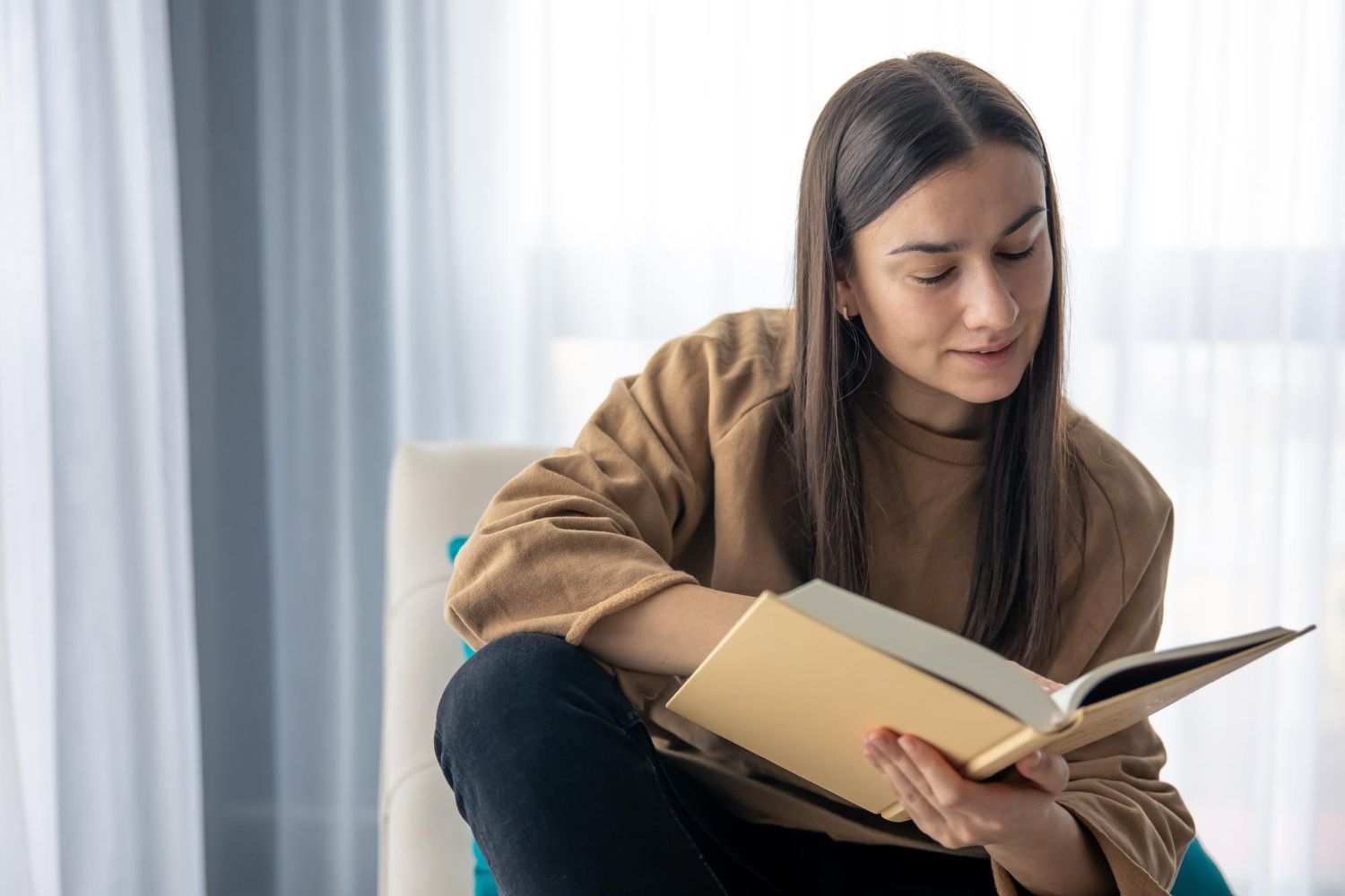 A mom of an autistic child reading a book about ABA therapy.
