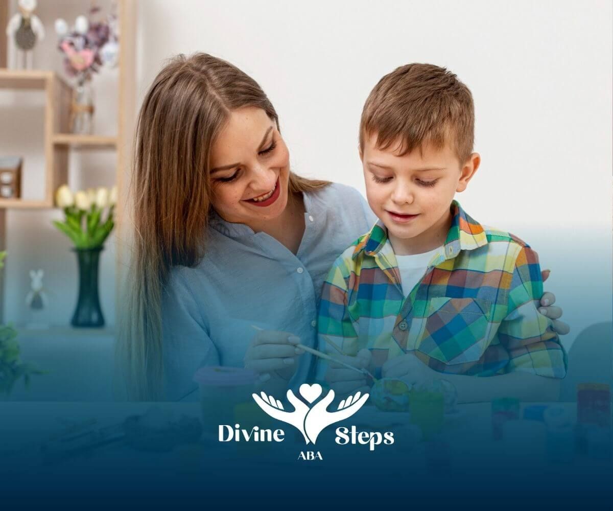 A BCBA and a boy are sitting at a table painting easter eggs during ABA therapy.