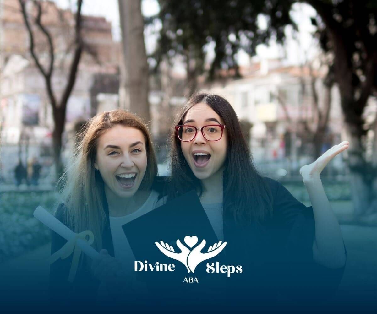 Two smiling ABA  graduates celebrating outdoors while holding a diploma & wearing graduation attire.