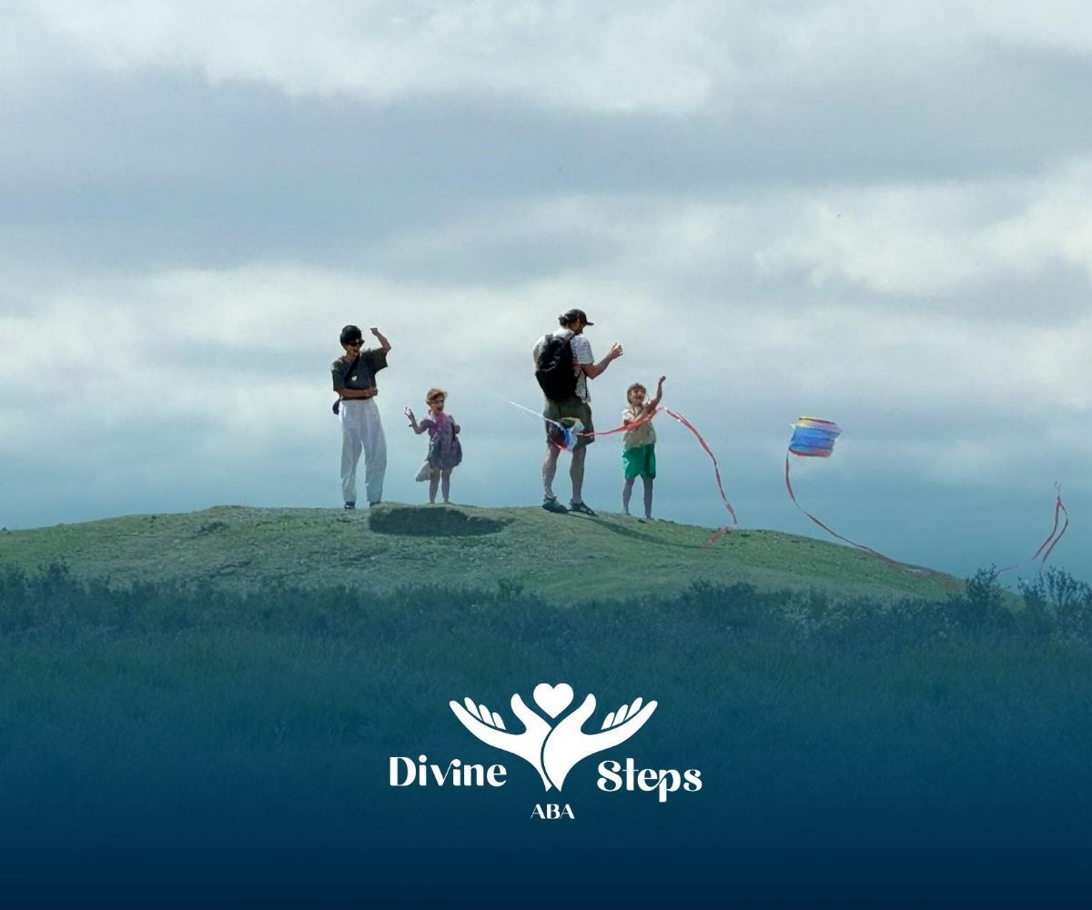 Family with autistic children flying a colorful kite on grassy hill during a trip in North Carolina.