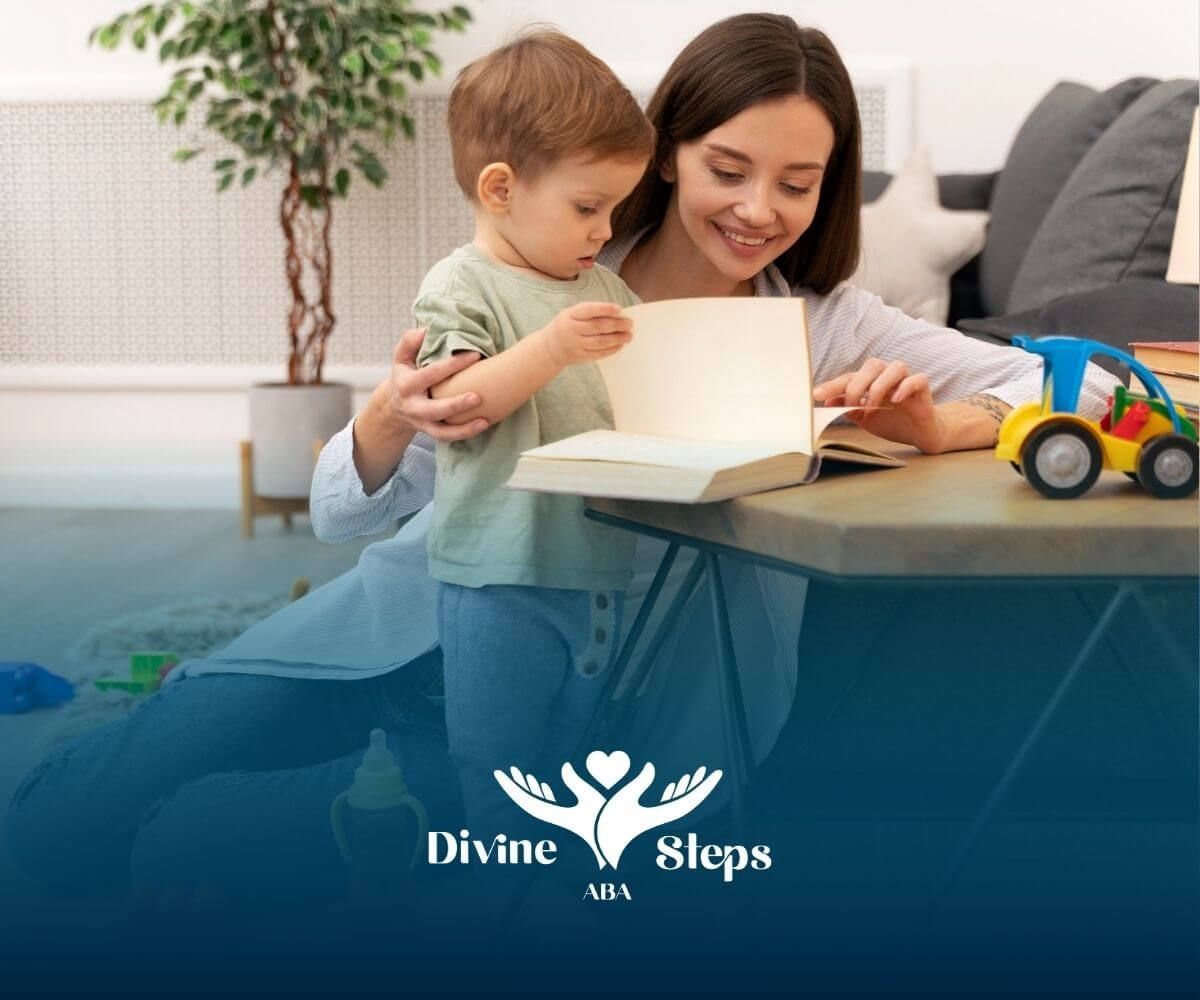 A BCBA is sitting on the floor reading a book to a little boy during ABA therapy.