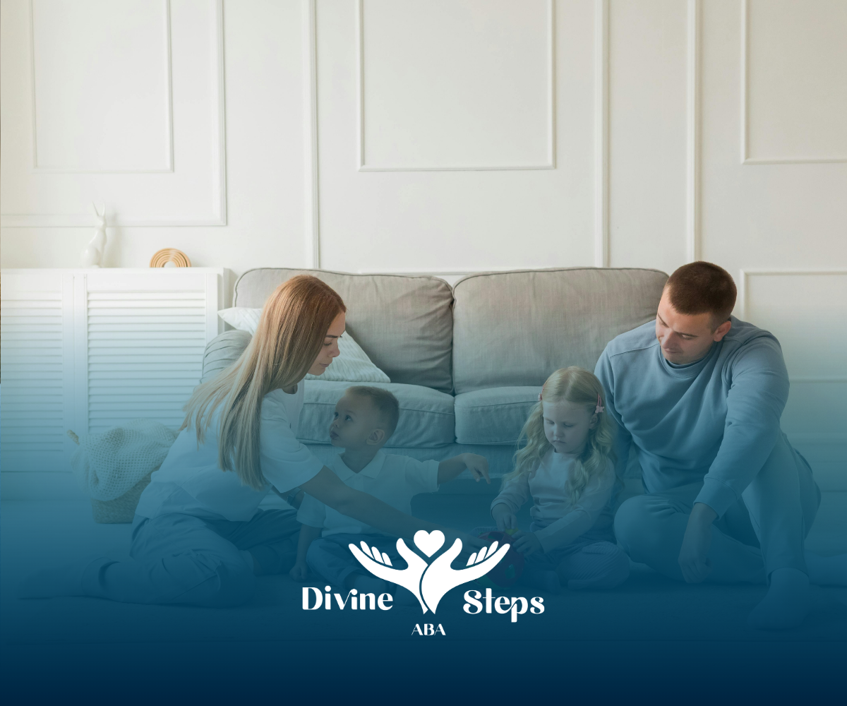Family sitting on floor; parents with two children, light-colored clothing in a living room.