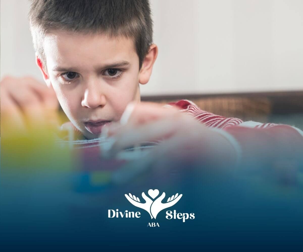 Young autistic boy concentrating while building colorful toy blocks during a focused learning.