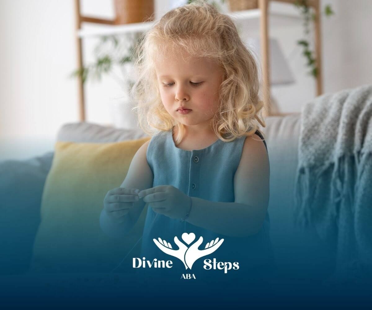 A little girl is sitting on a couch playing with a string in ABA therapy.