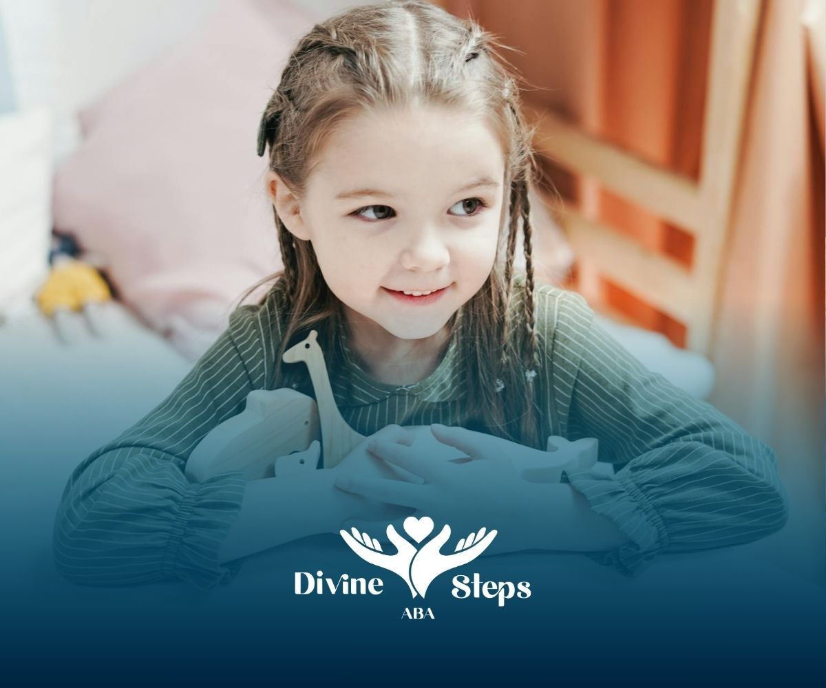An autistic girl hugging wooden animal toys while sitting at a white table, smiling softly in MD