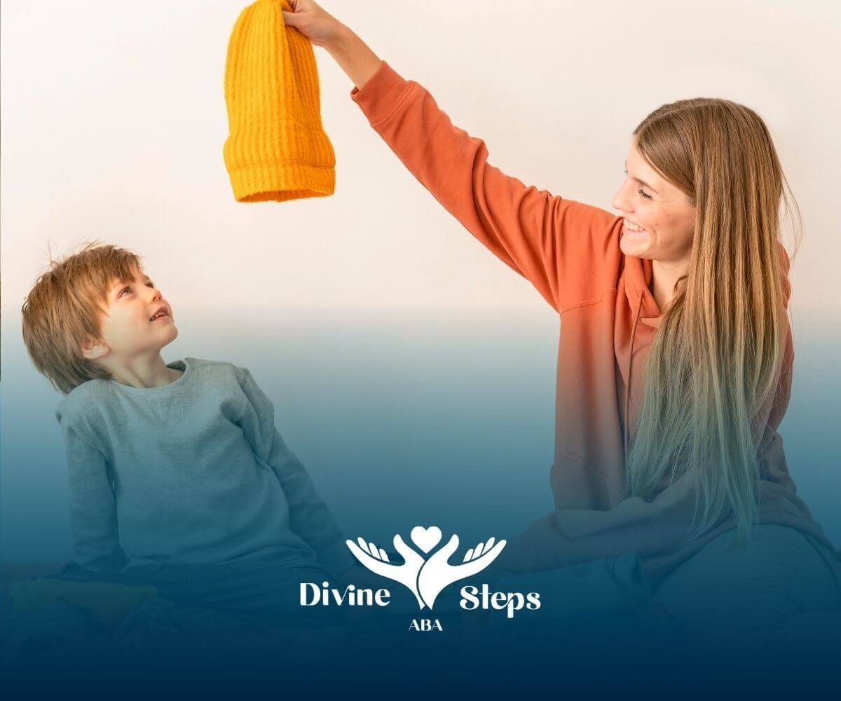 Therapist shows yellow knitted hat as autistic child looks up from suitcase of folded clothes