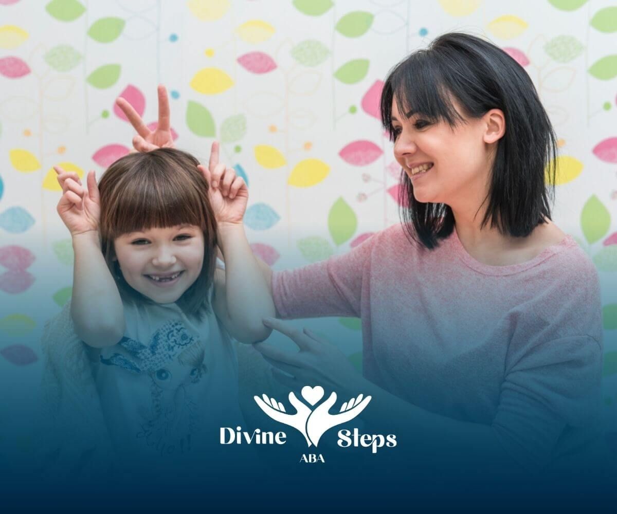 An ABA therapist and a little girl with autism are standing next to each other.