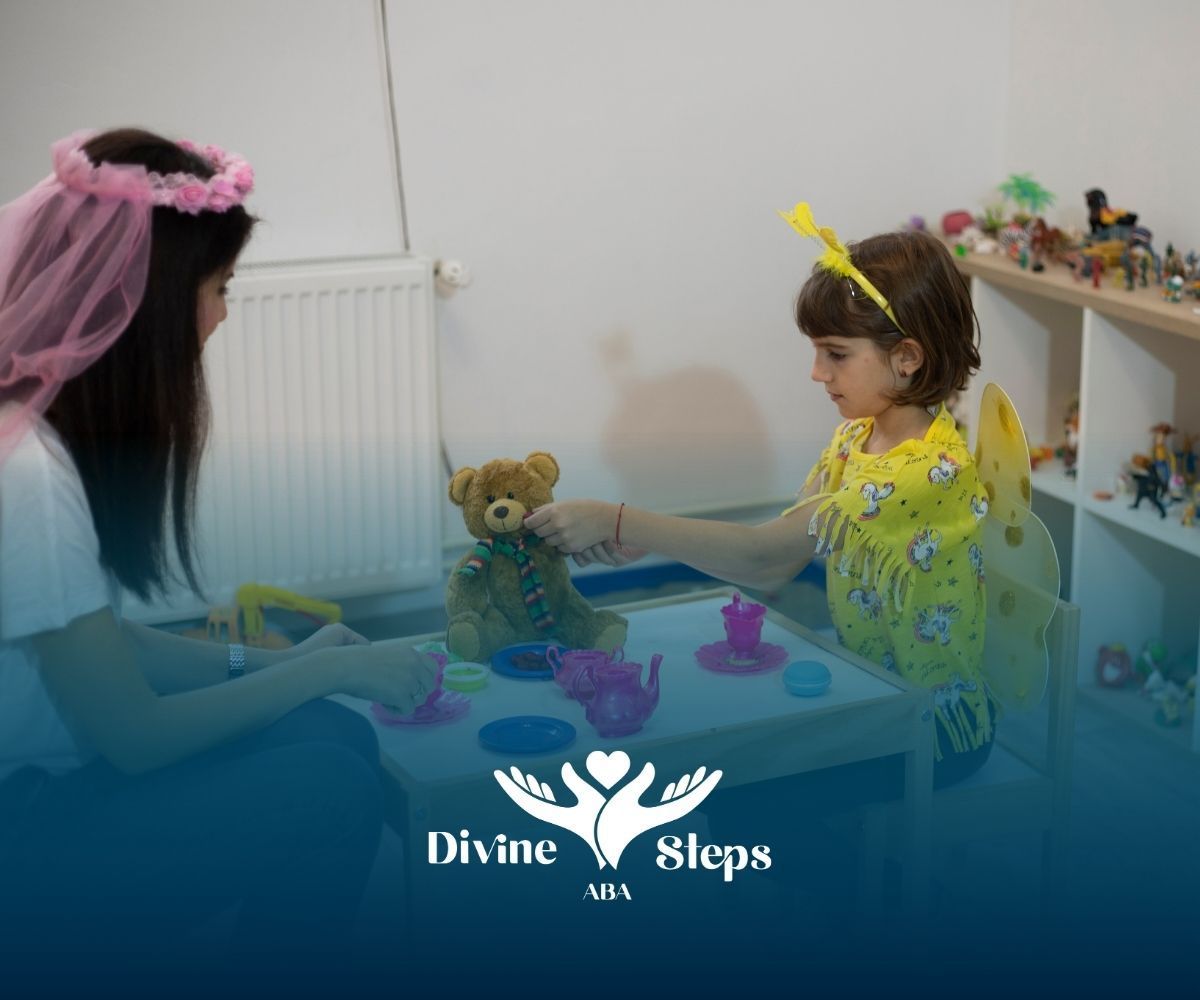 Woman and child playing with a teddy bear and tea set, indoors. Both are wearing headbands.