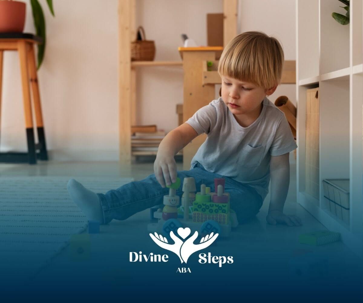 A young boy is sitting on the floor playing with a toy train during ABA therapy.