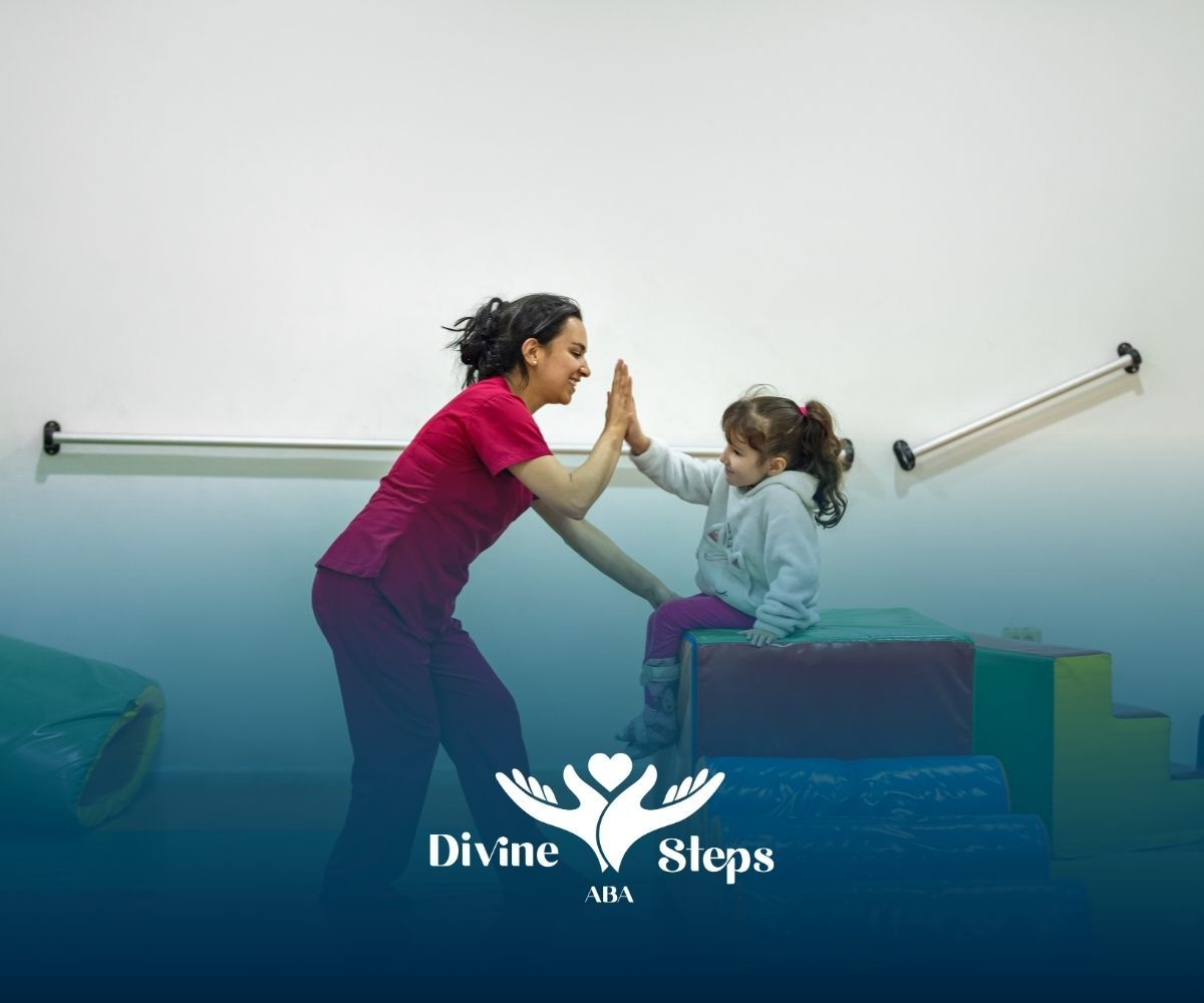 Woman in pink shirt high-fives a child sitting on colorful blocks; therapy setting.
