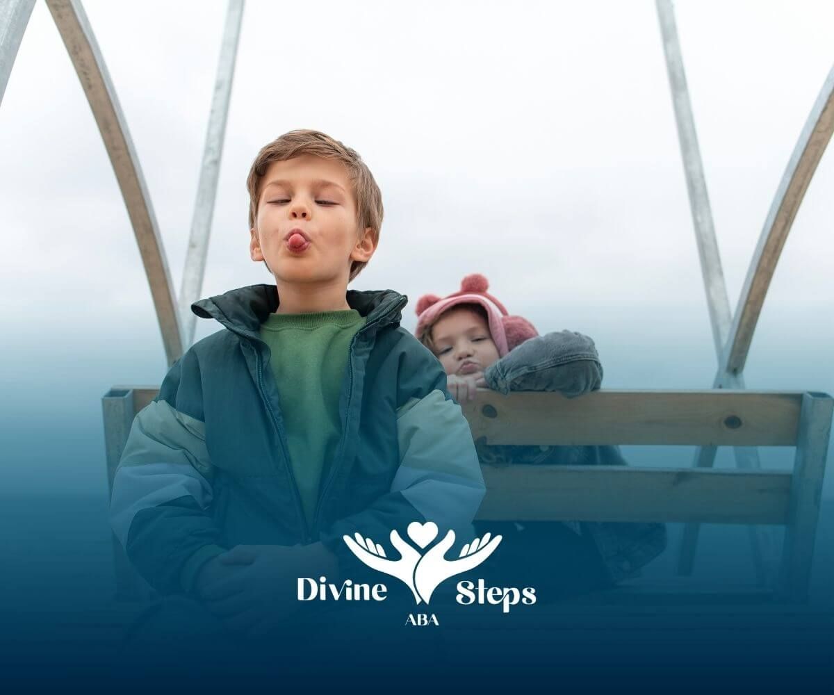 An autistic kid is sitting on a wooden bench by the beach, making a playful face while another child