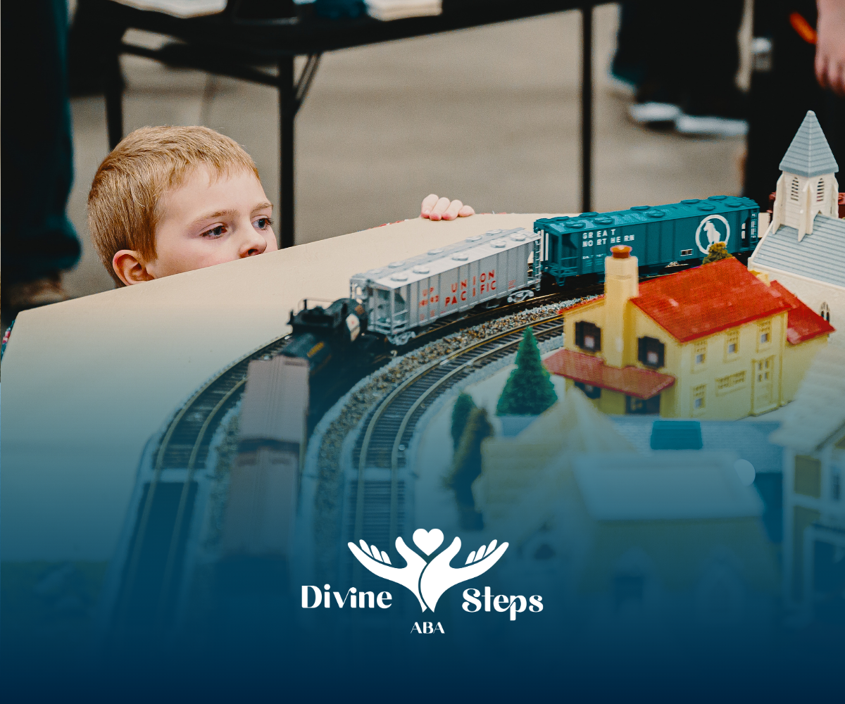 A young boy watches a model train on a layout.